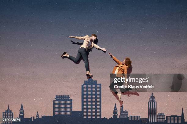 businesswomen reaching out for each other, while lying on asphalt painted as skyline - romper el hielo fotografías e imágenes de stock