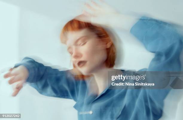 red haired woman in blue shirt dancing, blurred motion - long exposure - long exposure dance stock pictures, royalty-free photos & images