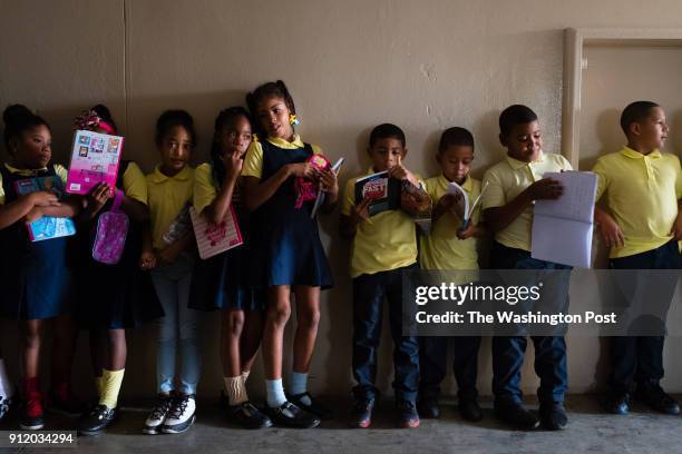 Class of 6th grades stand in line as they make their way through the dark halls of Escuela Intermedia Jesusa Vizcarrondo in Loiza, Puerto Rico to...