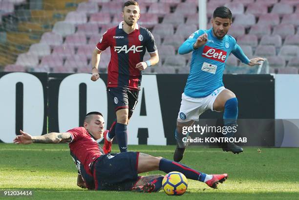 Napoli's Italian striker Lorenzo Insigne jumps over Bologna's Chilean midfielder Erick Pulgar as he fail to tackle him during the Italian Serie A...