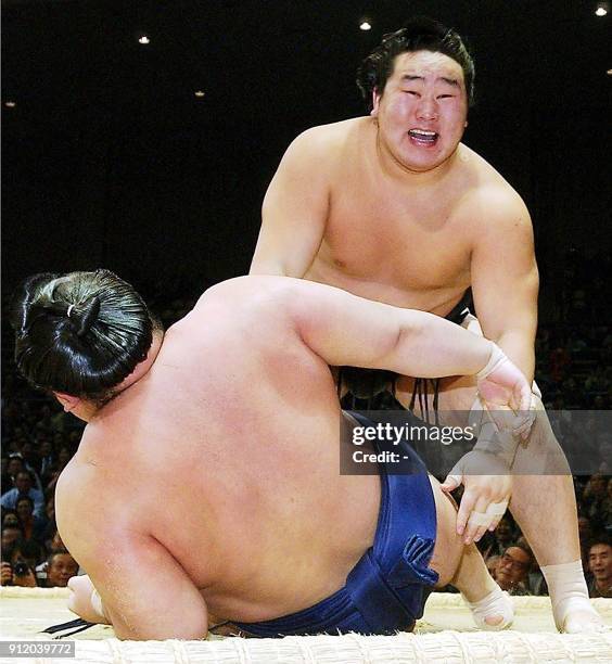 Mongolian sumo wrestler Asashoryu puts down Wakanosato onto the ring to get his 12th win during the 13th day of the Fukuoka Grand Sumo tournament in...