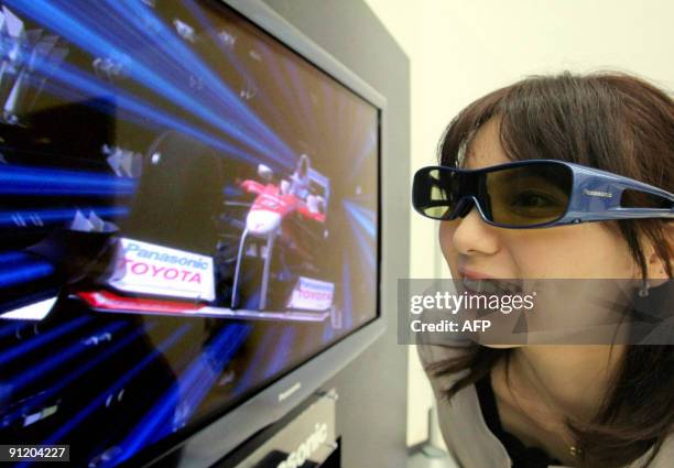 Woman views three-dimensional images through special glasses on one of Japanese electronics giant Panasonic's new 50-inch plasma display panel...