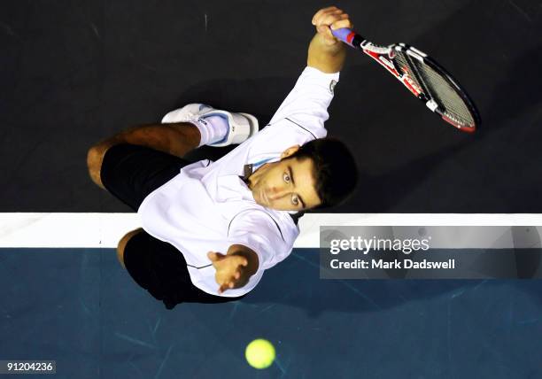 Benjamin Becker of Germany hits a serve in his doubles match with Leonardo Mayer of Argentina against Sonchat Ratiwatana and Sanchai Ratiwatana of...