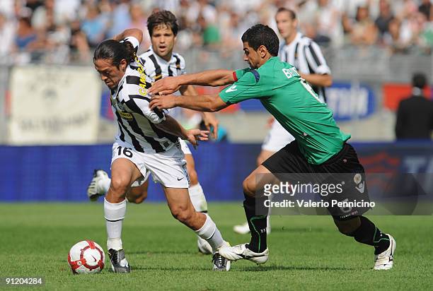 Mauro German Camoranesi of Juventus FC is challenged by Miguel Britos of Bologna FC during the Serie A match between Juventus FC and Bologna FC at...