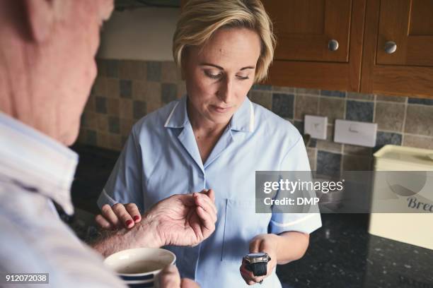 soignant, vérifier le pouls de l’homme senior - prendre le pouls photos et images de collection