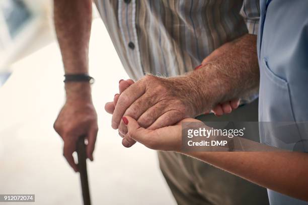 vrouwelijke verpleegkundige ondersteuning van senior man om te wandelen - aged care stockfoto's en -beelden