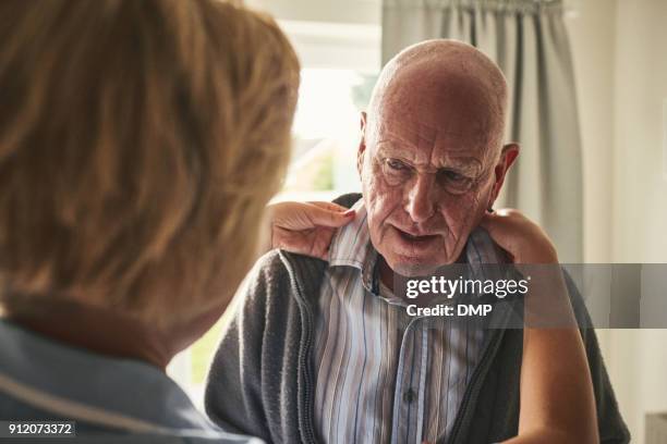 caregiver helps dressing elderly patient at home - nursing assistant stock pictures, royalty-free photos & images