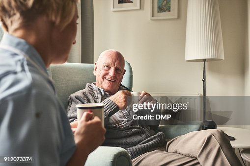 Smiling senior man talking to female caregiver Smiling senior man talking to female caregiver
