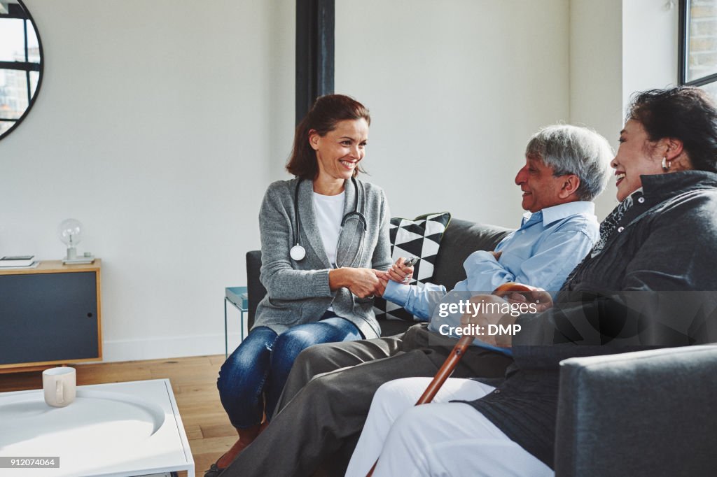 Female doctor visiting elderly couple