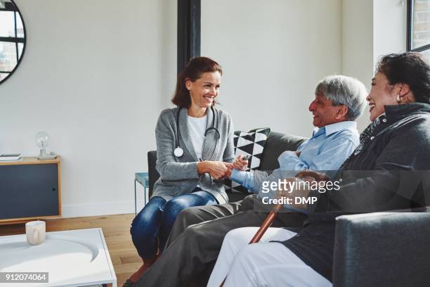 female doctor visiting elderly couple - gp visit stock pictures, royalty-free photos & images