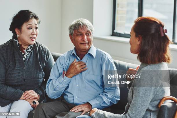 female carer treating senior couple - sign stock pictures, royalty-free photos & images
