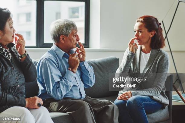 healthcare worker showing the pressure points to senior couple - acupuncture elderly stock pictures, royalty-free photos & images