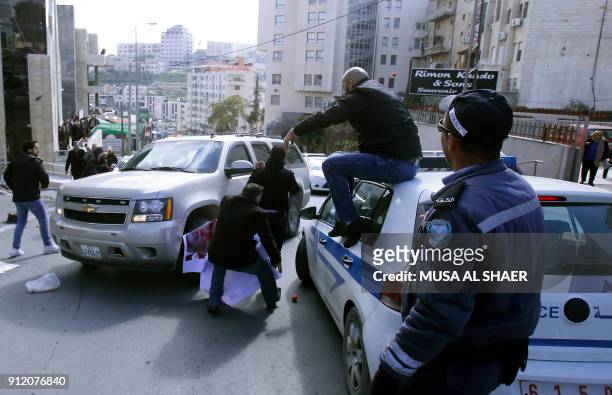 Palestinian activists throw tomatoes at a vehicle transporting members of an American economic delegation that are meeting with the Head of the...