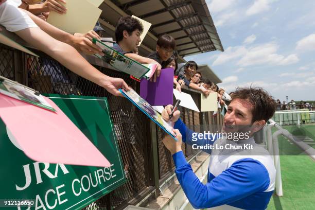 Jockey Mirco Demuro gives his autograph to Japanese racing fans during the Yasuda Kinen race day at Tokyo Racecourse on June 7, 2015.