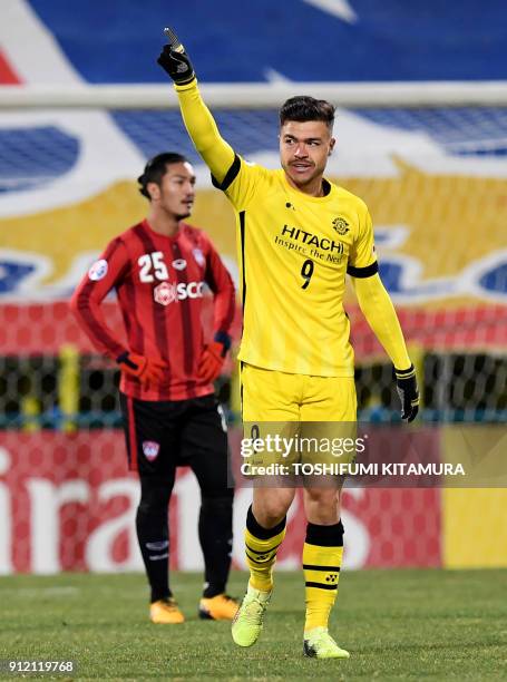 Japan's Kashiwa Reysol forward Cristiano Da Silva gestures after scoring a goal in front of Thailand's Muangthong United defender Adison Promrak...