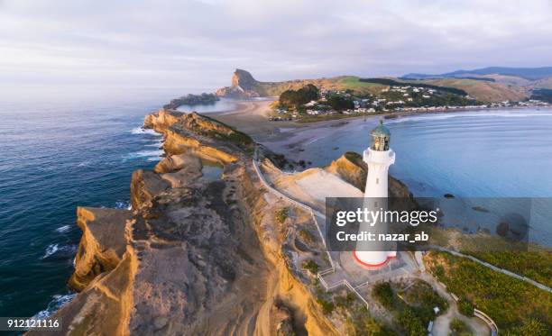 bovenaanzicht van castlepoint vuurtoren met castlepoint dorp op achtergrond. - wellington nieuw zeeland stockfoto's en -beelden