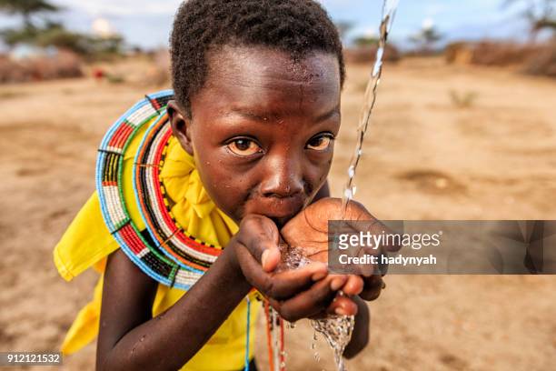 afrikaanse meisje van samburu stam vers drinkwater op savanne., oost-afrika - african girl drinking water stockfoto's en -beelden