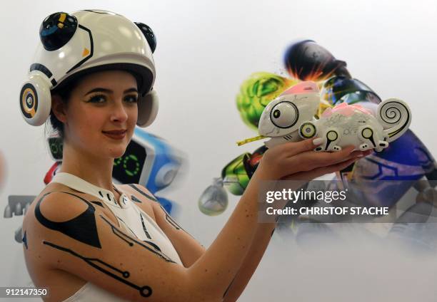 An hostess presents a toy robo chameleon at a booth during the press preview of the international toys fair in Nuremberg, souhtern Germany, on...