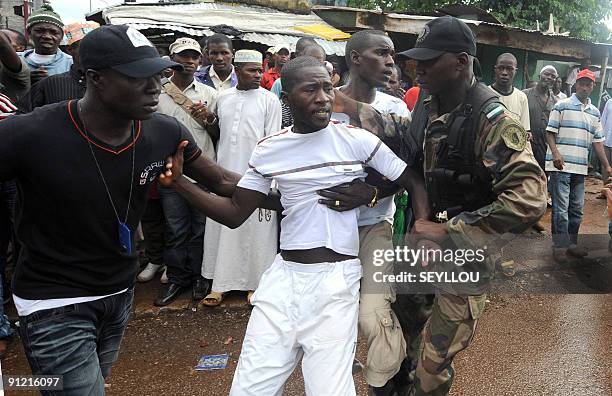 Guinean police arrest a protester on September 28, 2009 in front of the biggest stadium in the capital Conakry during a protest banned by Guinea's...