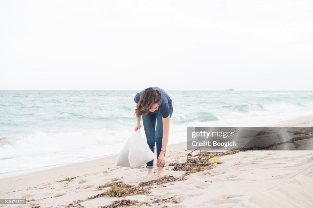 Environmentally Conscious Millennial Woman Cleans Up Beach Miami Florida