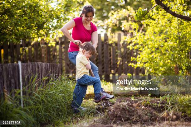 mother and daughter together digging the soil - graben stock-fotos und bilder