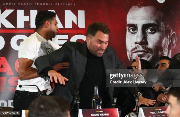 Eddie Hearn gets inbetween Amir Khan and Phil Lo Greco after Amir Khan throws a glass of water at Phil lo Greco during an Amir Khan and Phil Lo Greco...