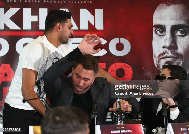 Eddie Hearn gets inbetween Amir Khan and Phil Lo Greco after Amir Khan throws a glass of water at Phil lo Greco during an Amir Khan and Phil Lo Greco...