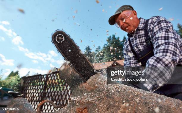 senior man cutting logs - tradesman with chainsaw stock pictures, royalty-free photos & images