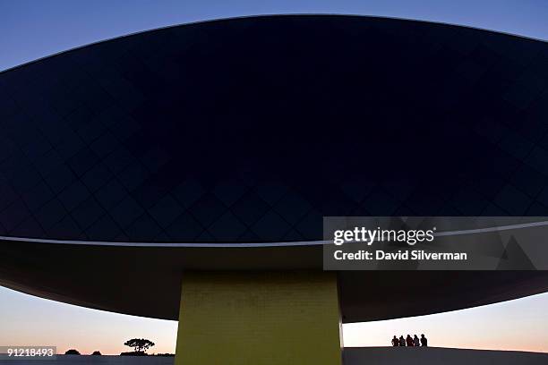 Visitors watch the sunset from the Oscar Niemeyer Museum, the largest museum in Latin America, on August 15, 2009 in Curitiba, the capital city of...