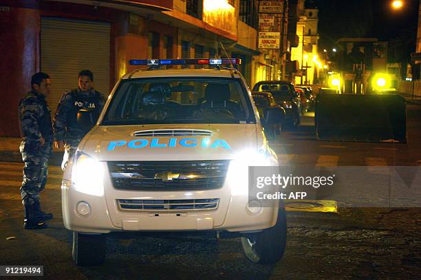 Group of policemen stand guard next to an earth mover at the South Pan American highway in Salcedo, 120 km south of Quito, which remained unblocked...