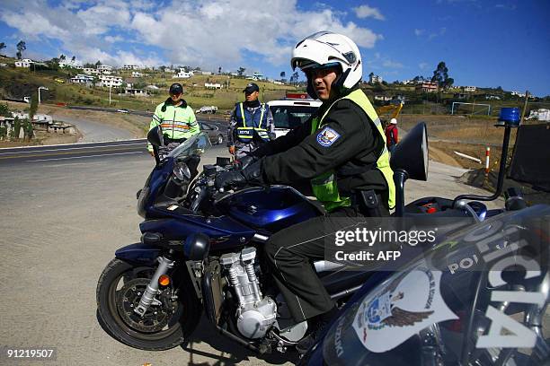 Policemen stand guard at the South Pan American Highway 10km south of Quito, which remained unblocked and calm despite the threat of an indigenous...
