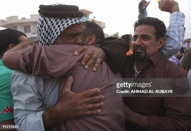 Father hugs one of his two released sons on September 28 in Baghdad after being freed from jail. Thirty two men were released today part of a batch...