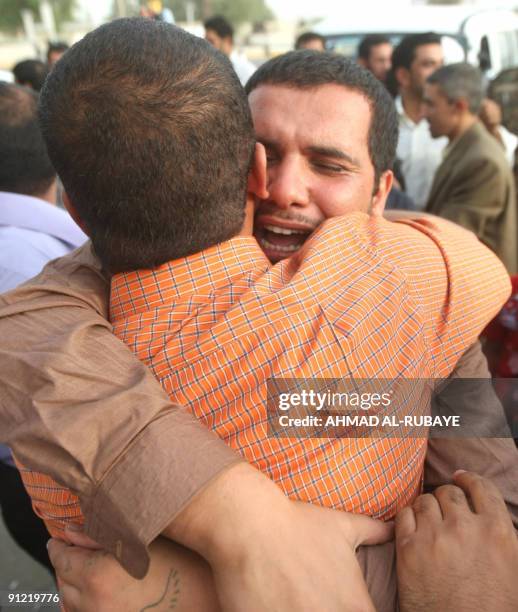 An Iraqi man hugs his released brother on September 28 in Baghdad after being freed from jail. Thirty two men were released today part of a batch of...