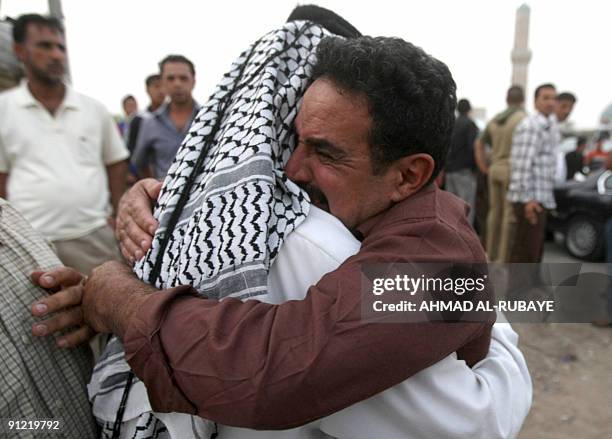 An Iraqi man hugs his released son on September 28 in Baghdad after being freed from jail. Thirty two men were released today part of a batch of more...