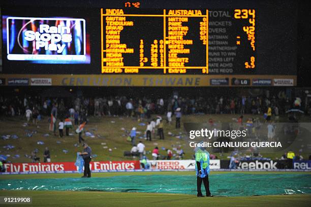 Pitch marshalls stands close to the pitch as rain falls stopping the game between Australia and India on September 28, 2009 during the ICC Champions...