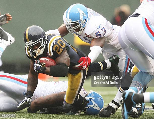 Thomas Jones of The New York Jets is tackled by Keith Bulluck of The Tennessee Titans during their game on September 27, 2009 at Giants Stadium in...
