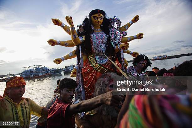 Devotees carry an idol of Hindu goddess Durga before immersing it into the river Ganges on the last day of the Durga Puja festival on September 28,...