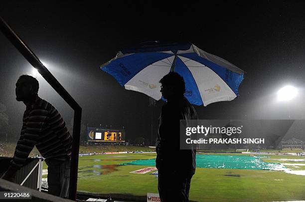 Spectators wait as the ICC Champions Trophy match between India and Australia was suspended due to rain at SuperSport Park in Centurion on September...