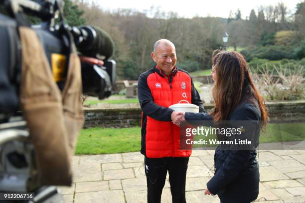 Eddie Jones, head coach of England is presented with a birthday cake by Sky Sports presenter Gail Davis during England media access at Pennyhill Park...