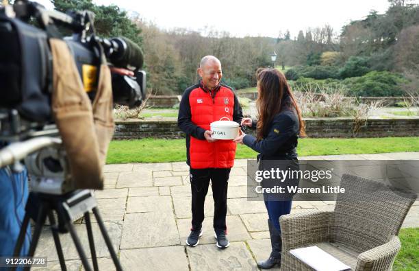 Eddie Jones, head coach of England is presented with a birthday cake by Sky Sports presenter Gail Davis during England media access at Pennyhill Park...