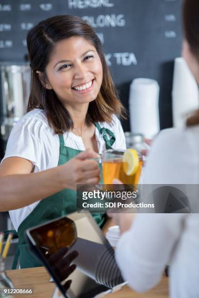 friendly barista hands customer cut of hot tea - hot filipina women stock pictures, royalty-free photos & images