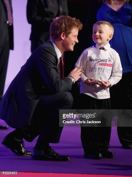Prince Harry presents Alex Burke, age six, with the Bravery Award during the WellChild Awards at the Intercontinental Hotel on September 28, 2009 in...