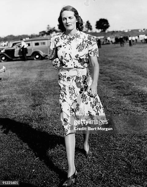 American socialite Eleannor Searle Whitney , wife of Cornelius Vanderbilt Whitney, walks across the grass as she arrives for a polo match at the...