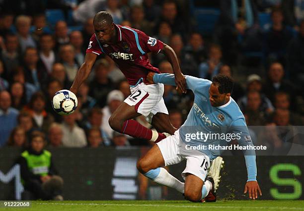 Carlton Cole of West Ham United tangles with Joleon Lescott of Manchester City during the Barclays Premier League match between Manchester City and...