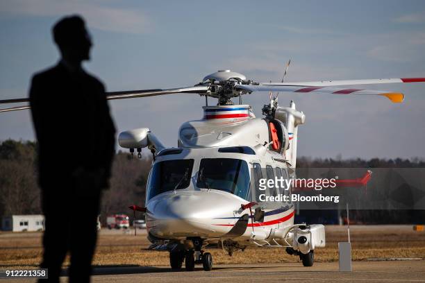 Silhouetted attendee stands in a hangar near an AgustaWestland AW109 AW 189 helicopter during an investor day at a Leonardo SpA plant in Vergiate,...