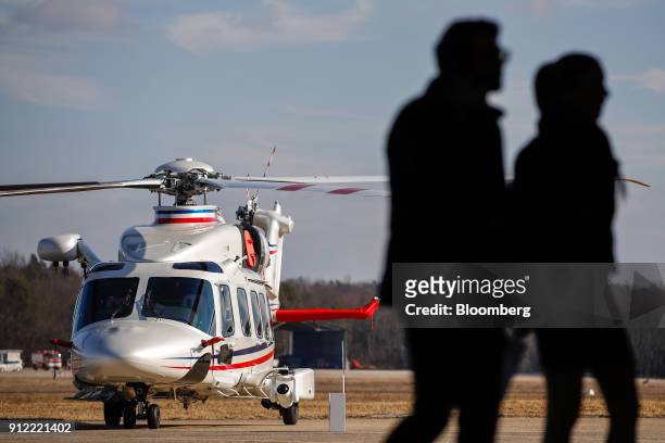 Attendees stand silhouetted next to an AgustaWestland AW189 helicopter during an investor day at a Leonardo SpA plant in Vergiate, Italy, on Tuesday,...