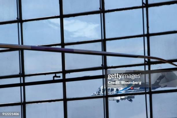 Helicopter is flies past a hangar window during an investor day at a Leonardo SpA plant in Vergiate, Italy, on Tuesday, Jan. 30, 2018. Leonardo said...