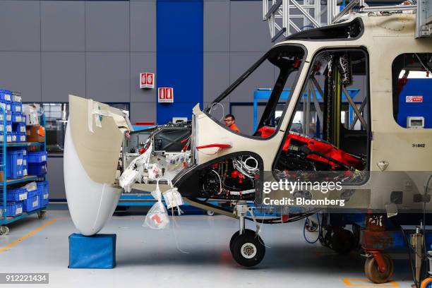 An employee walks past an AgustaWestland AW139 helicopter at a Leonardo SpA plant in Vergiate, Italy, on Tuesday, Jan. 30, 2018. Leonardo said it...