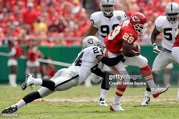 Dantrell Savage of the Kansas City Chiefs carries the ball against Michael Huff of the Oakland Raiders during the game at Arrowhead Stadium on...