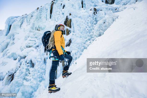ice climber in front of frozen waterfall pyrenees france - crampon stock pictures, royalty-free photos & images